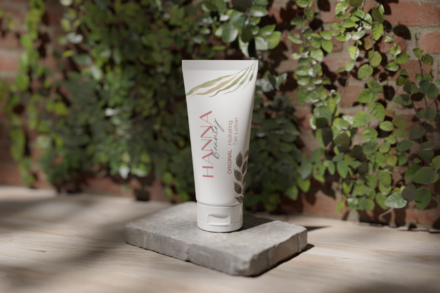 A product shot shows a white tube of "HANNA beauty" "Original Hydrating Tan Lotion" resting on a small, gray stone. The background is a brick wall partially covered in green ivy.