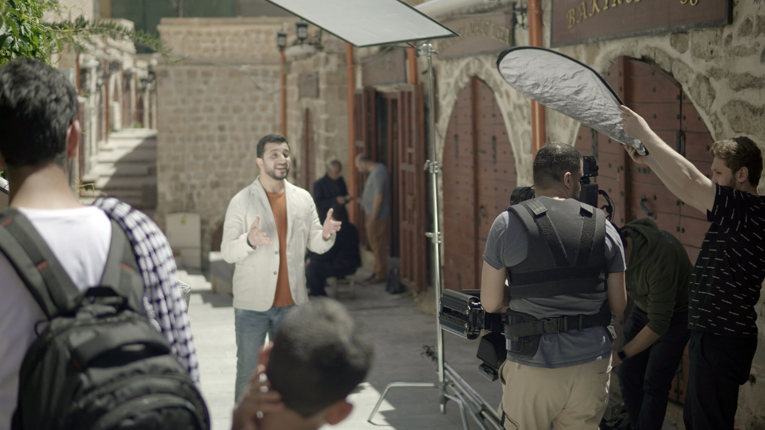 A man is gesturing and singing as he gets filmed