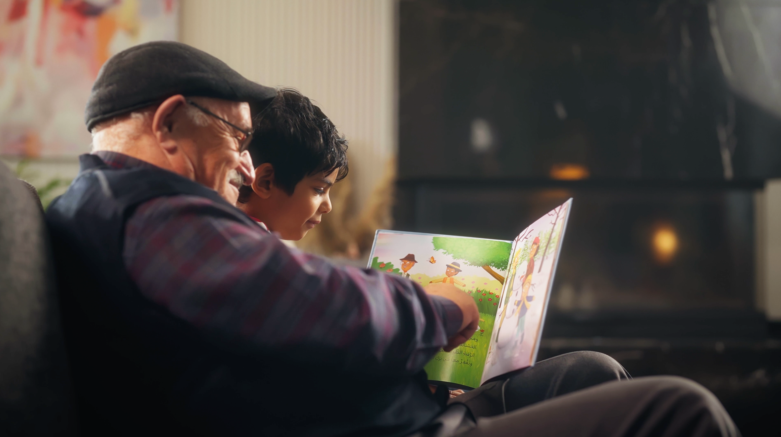 A grandfather and a child read a picture book together